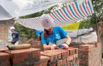 person wearing a hard hat building a structure