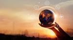 image of person holding up globe with city in the background