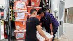 Two people loading containers into the back of a van