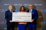 Three people posing with an oversized check