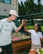 A student high-fives LA Galaxy’s JT Marcinkowski.