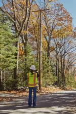 Worker looking up at powerlines