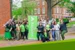 A group of people posing outside next to a Regions banner