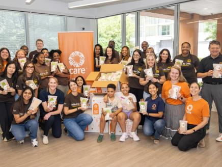 volunteers posing for a group photo with CARE packages