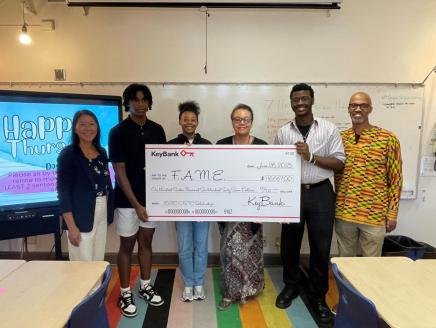 Representatives from FAME and KeyBank shown with a check for $116,670.