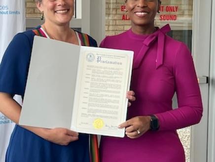 Dutchess County Mental Health Commissioner Jean-Marie Niehbur (left) presents a proclamation on half of County Executive Sue Serino’s office to KeyBank’s Senior Area Retail Leader Irenee Provenzano.