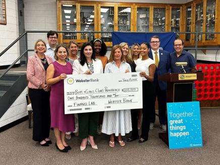 Photo: Marissa Weidner, Chief Corporate Responsibility Officer at Webster Bank (fifth from left) and Nicole Dufresne, CEO, Boys & Girls Clubs of Providence (seventh from left) are joined by members of the Boys & Girls Club team and Webster Bank staff to celebrate the launch of the Webster/Providence Finance Lab at the Boys & Girls Clubs of Providence Fox Point Clubhouse on Tuesday, July 15.