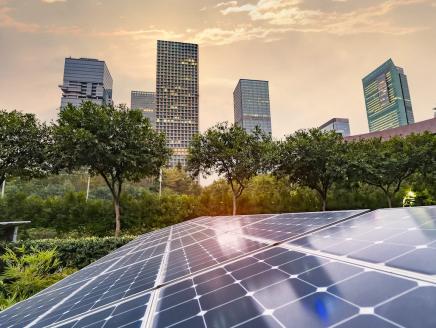 Solar panel array with a cityscape in the background.