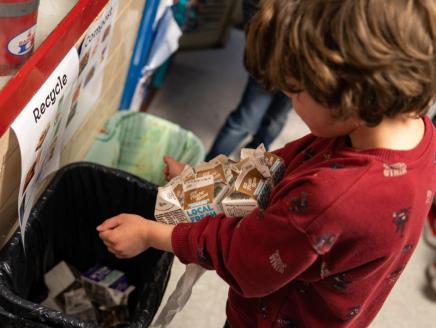 child recycling a carton