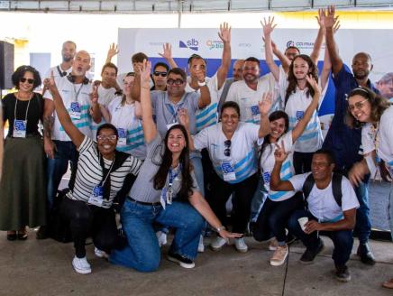 A group of people smiling and raising their arms