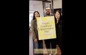 Tapestry employees holding employee appreciation day sign