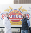 Two people speaking in front of Stafford Bakery truck
