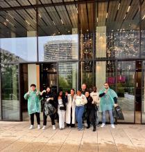 A group posed outside a building. Some giving thumbs-up.