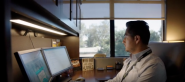 A man sitting at a desk with two monitors