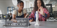 Two girls working at a table, focused on a small robot. "Sending girls to code camp." on the bottom left.