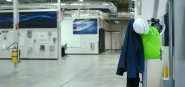 An empty industrial room, coat and hardhat on a stand.