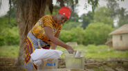 Woman scooping out clean water from a P&G bucket