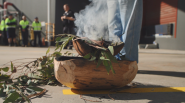 A person standing next to a ceremonial fire