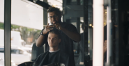 A person getting a haircut in a barber chair.