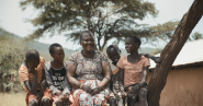 Lucy Tomee and four children sitting on a bench outside.