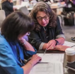 Two people looking at a diagram on a shared table.