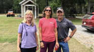 three people standing together outside