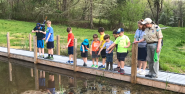 A group of children on a trail overlooking a body of water.