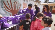 Volunteers giving bags to children