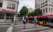 pedestrians crossing a city street in front of a Walgreens