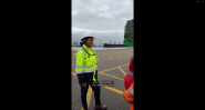 Cynthia Garrido, wearing a hard hat and high-visibility PPE, speaks with colleagues at DP World's container terminal in Callao, Peru