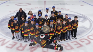 Kids posing on the ice with mascot