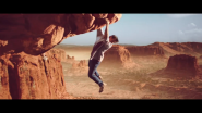 man hanging from mountainous rockface looking down