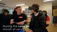 Person in VR headset facing a man in a Lenovo t-shirt