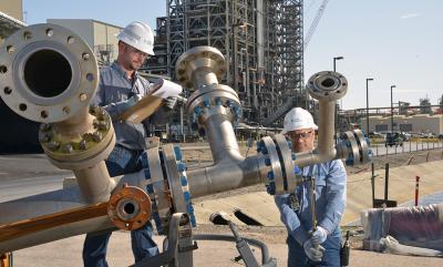Maintenance team members Mitchell Thorne and John Koenig make a final adjustment to a gasifier feed injector, a key piece of equipment.