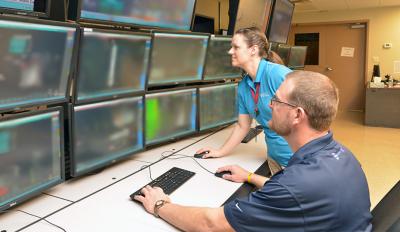 Scott Goodman and Elizabeth Huber prepare the training simulator. New operators learn how to run the plant, monitor systems and identify and respond to changing conditions.