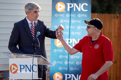 Jim Hansen, PNC regional president of Eastern Carolinas, hands the keys to his mortgage-free home to Former Master Sgt. Michael Levine during a Nov. 7 event.