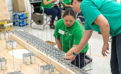 SCE volunteers used metal rods with nuts and bolts to tighten each layer of plywood for their Canstruction electric bucket truck.