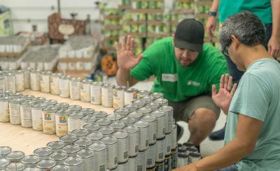 SCE volunteers hold their breath to see if the cans will hold as they build their Canstruction version of an electric bucket truck.