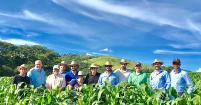 Franciele Caixeta in a corn field with colleagues from General Mills and Ag Alumni Seed, along with producers and partners of the research company, Terra Gerrais.