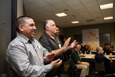 David Guzman (left), SCE Vegetation and Forestry manager, applauds at the end of an Operation Santa Ana presentation.