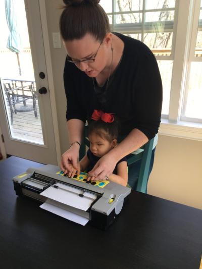 Lela Imhoff started learning braille literacy skills with Jennifer Cox, a Teacher of Students with Visual Impairments (TVI). In this photo, Cox is introducing Lela to a Mountbatten Brailler, a braille typewriter that will enable Lela to write on paper.