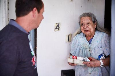 Meals on Wheels volunteer delivering meal during event in San Antoino.