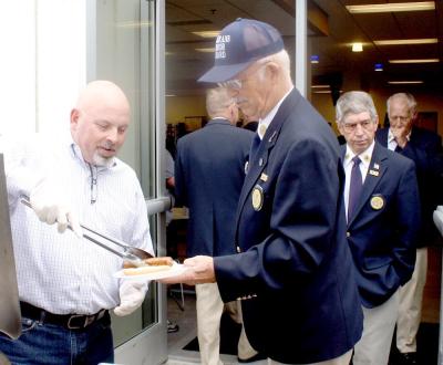 WHIRLPOOL PLANT Manager Dicky Walters, left, is shown serving hot dogs to members of the Bradley County Funeral Honor Guard. Accepting one is guard member John Thomason. Photo Credit: Larry C. Bowers