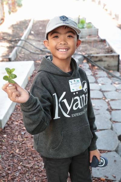 A student from Dolores Street Elementary shows off the mint he harvested during a Protect the Pitch Field Trip at Dignity Health Sports Park on Thursday, December 5, 2019.