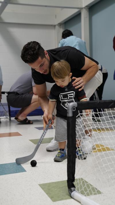 LA Kings prospect Sean Durzi plays ball hockey with a patient at the Pediatric Therapy Network in Torrance, Calif. during a team visit on June 27, 2019.