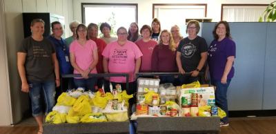 Accounting employees at Smithfield Foods’ hog production division in Missouri pose with their donation for Hunger Action Month, a time when people across the country stand together with Feeding America and its nationwide network of food banks to fight hunger.