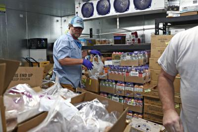 Rick Small, a Sysco Foods chef, and Jason Haddock, Sysco district sales manager, bag groceries Thursday off Carlton Road in Charlottesville. Sysco, in partnership with The Catering Outfit, is providing free groceries to restaurant workers who have become unemployed because of the coronavirus pandemic. (ERIN EDGERTON/THE DAILY PROGRESS)