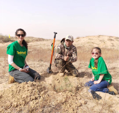 The author, her daughter, and a Green Net staff member paused to admire the tree they just planted in Inner Mongolia’s Horqin Desert. Since 2001, Timberland and Green Network have worked together to plant 2.6 million trees to help stop the spread of the desert, reduce sandstorms, and improve air quality as far away as Japan.
