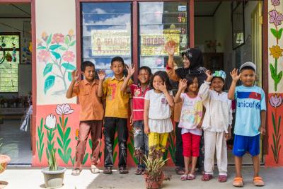 Young children with their teacher outside of a school that the members of the KBQB Coffee Cooperative chose to build with some of their Fair Trade Community Development Funds. Now the children don't have to bus to a school further away.