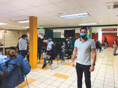 Garcia stands inside a COVID-19 vaccination facility, where he and his wife help Georgians complete paperwork and answer any questions while they wait to get vaccinated.